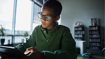 Collégien lisant sur une tablette